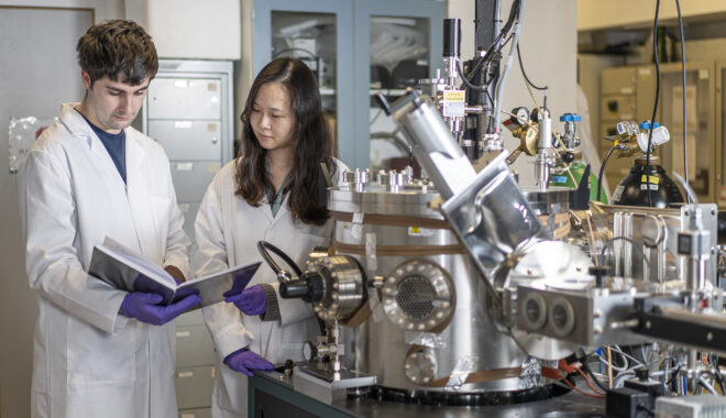 Two researchers working at Royce Cambridge's Physical Vapour Deposition and Characterisation Facility