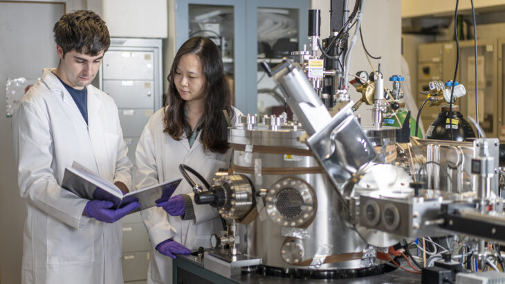 Two researchers working at Royce Cambridge's Physical Vapour Deposition and Characterisation Facility